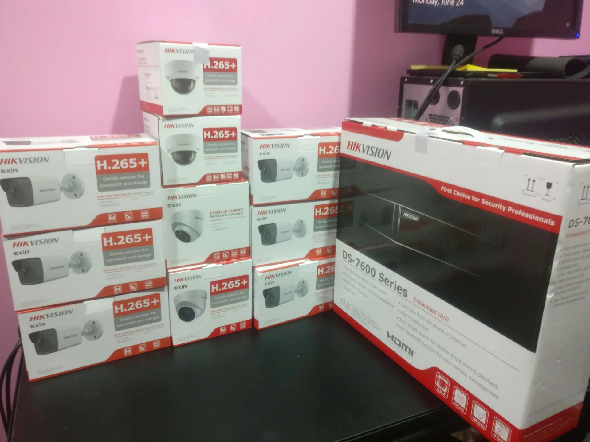 Multiple CCTV camera boxes and DVR system on a table (Hikvision branding visible) Hikvision CCTV cameras and DVR units for commercial security installations in Trinidad